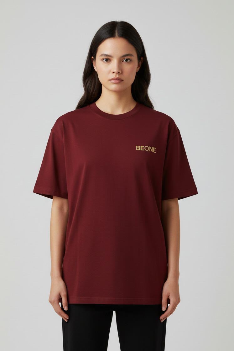 Person wearing a burgundy t-shirt with 'BEONE' logo on a light gray background