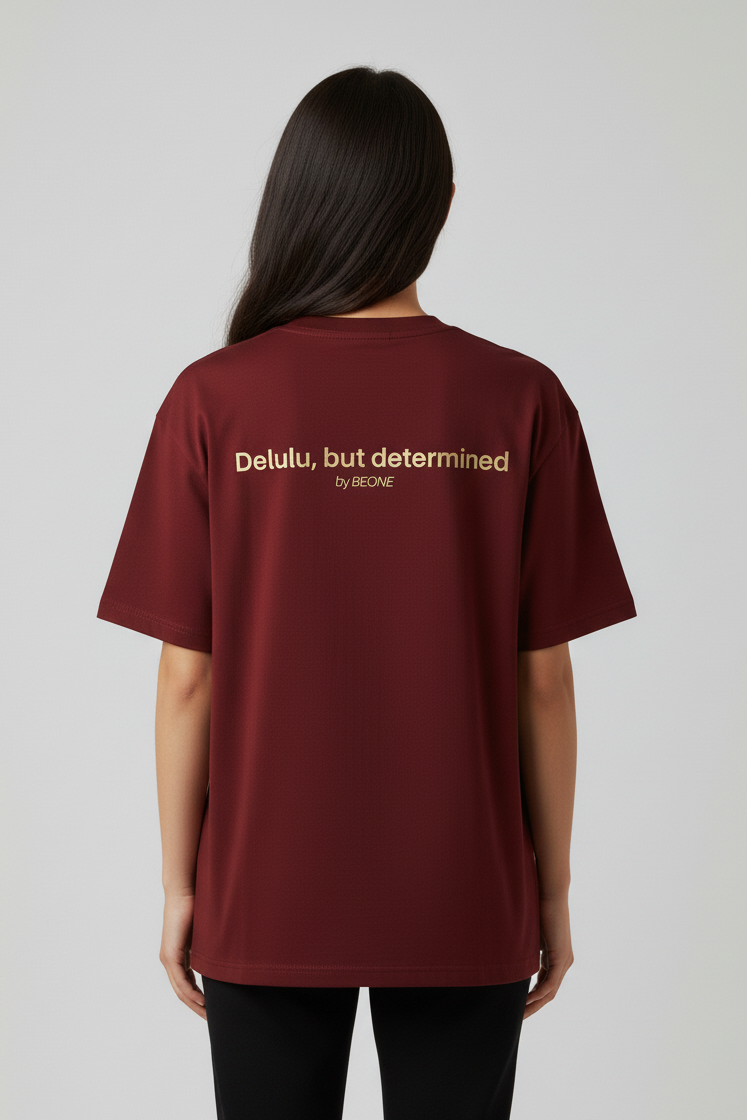 Person wearing a maroon t-shirt with text on the back against a plain background