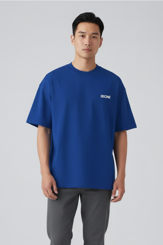 Man wearing a blue t-shirt with a logo on a white background