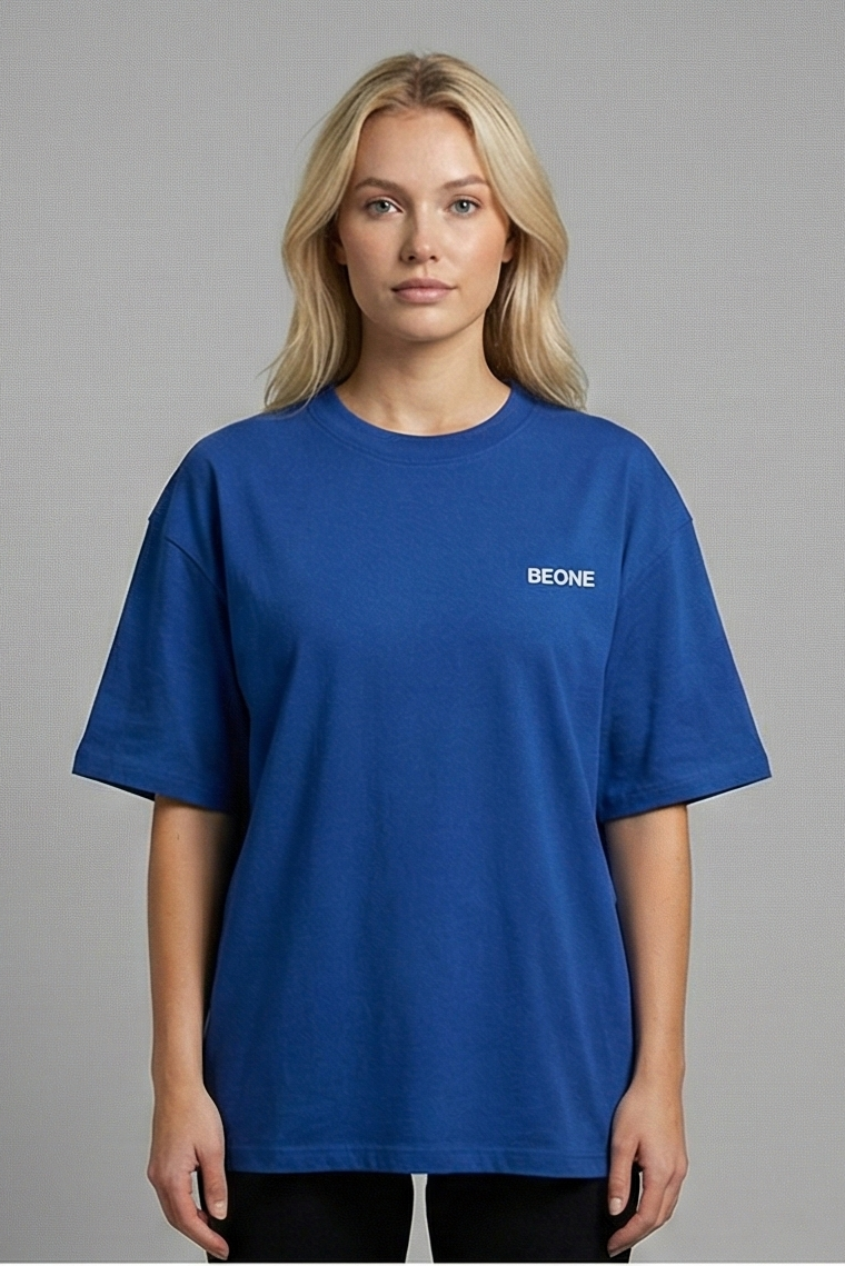 Person wearing a blue t-shirt with a logo on a gray background