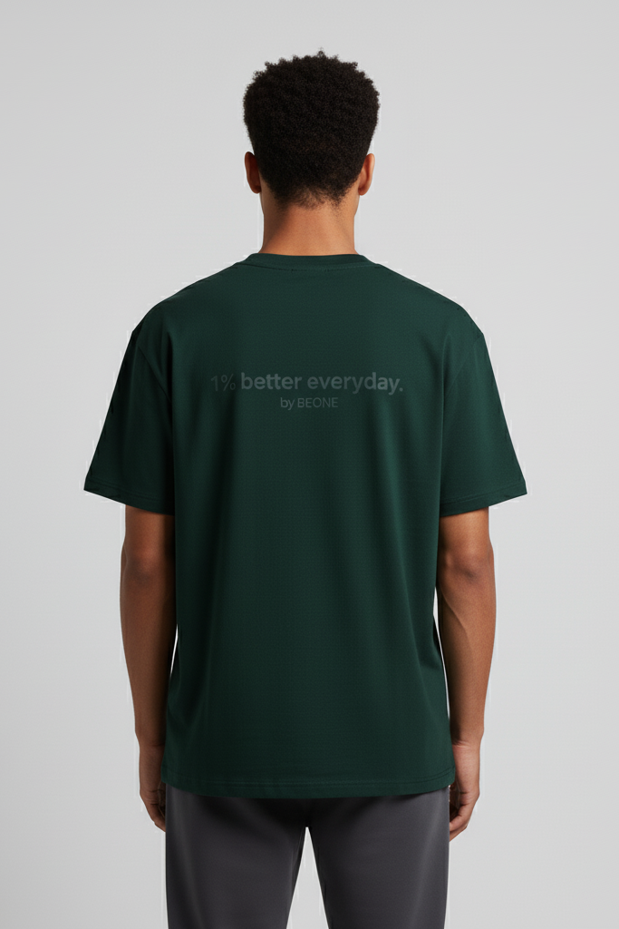 Person wearing a green t-shirt with text on the back against a gray background