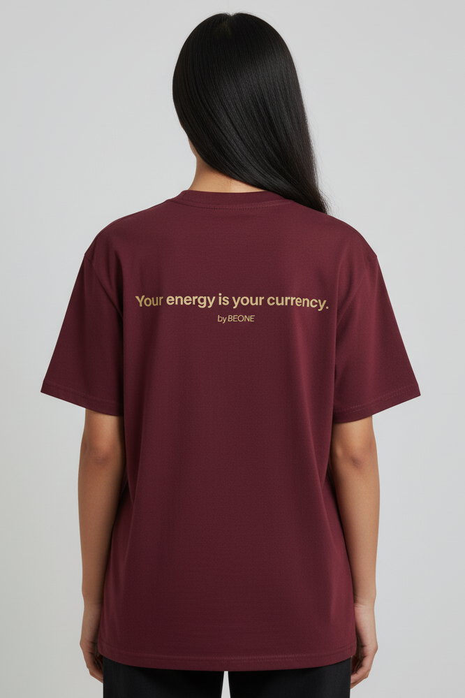Person wearing a burgundy t-shirt with text on the back against a gray background