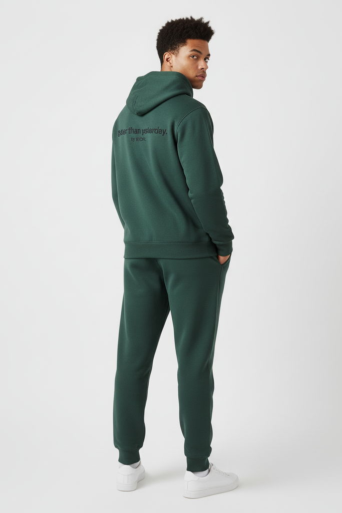 Person wearing a green tracksuit with text on the hood against a white background