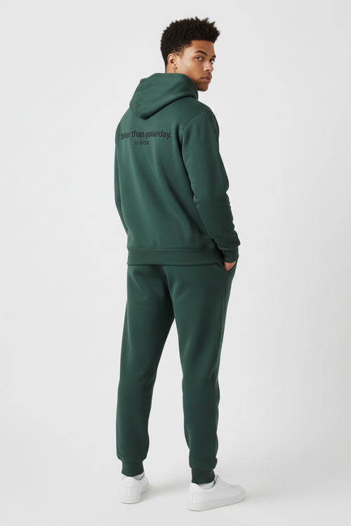 Person wearing a green tracksuit with text on the hood against a white background